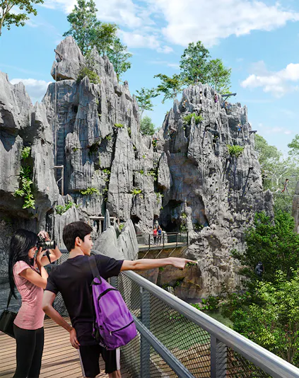 Visitors on a walkway exploring rocky terrain in Rainforest Wild Asia.