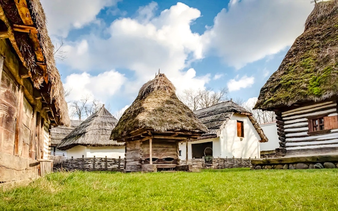 Traditional thatched-roof houses at Dimitrie Gusti National Village Museum, Bucharest.