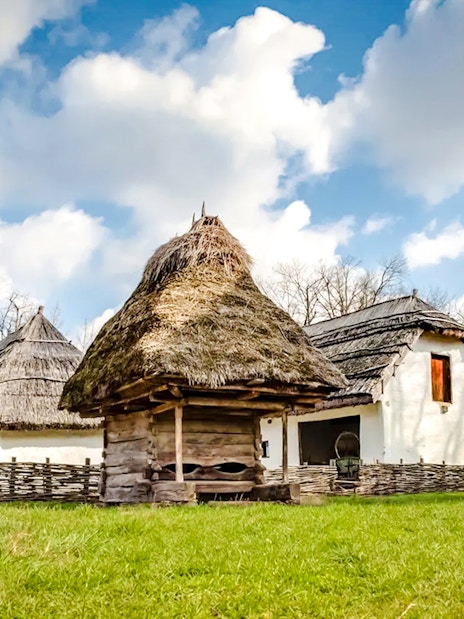 Traditional thatched-roof houses at Dimitrie Gusti National Village Museum, Bucharest.