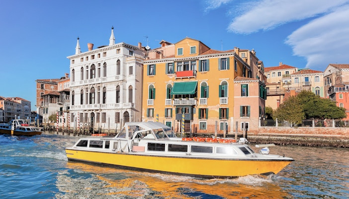 Alilaguna water bus navigating Venice's Grand Canal with cityscape in the background.