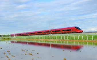 High-speed train traveling through countryside between Rome and Florence.