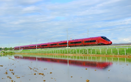 High-speed train traveling through countryside between Rome and Florence.