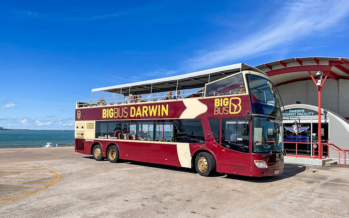 Darwin double-decker tour bus parked near waterfront and tourist facility.