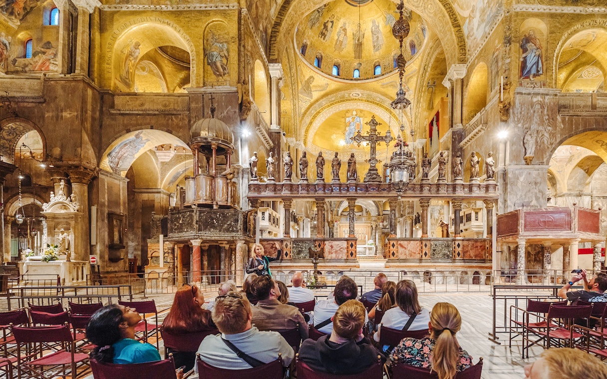 Tour group inside St. Mark's Basilica, Venice, admiring ornate interior after hours.