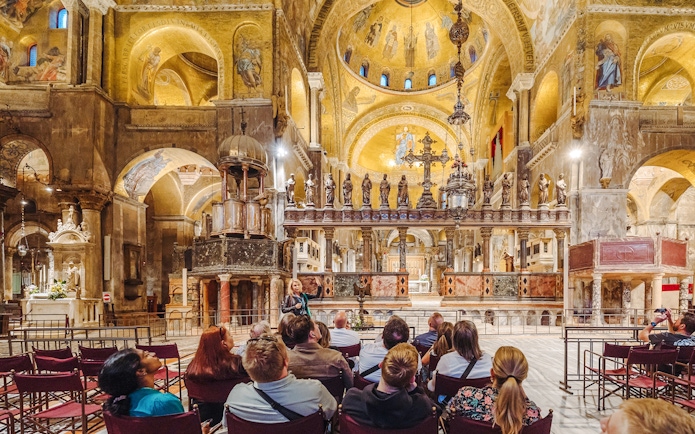 Tour group inside St. Mark's Basilica, Venice, admiring ornate interior after hours.