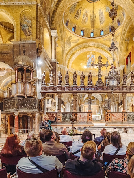 Tour group inside St. Mark's Basilica, Venice, admiring ornate interior after hours.