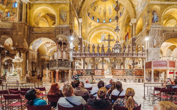 Tour group inside St. Mark's Basilica, Venice, admiring ornate interior after hours.