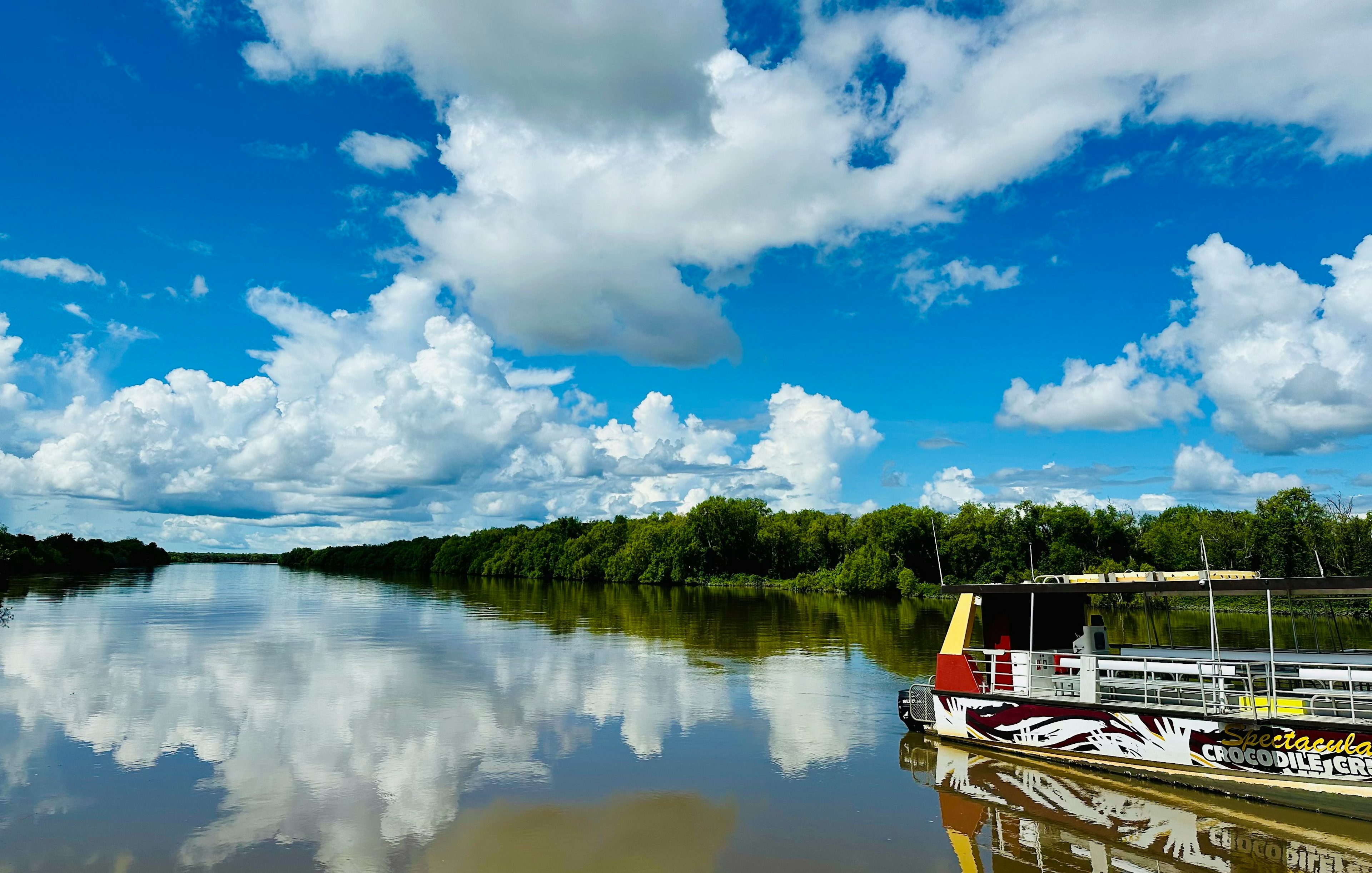 Boat on Adelaide River for Jumping Crocodile Cruise under blue sky.