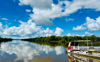Boat on Adelaide River for Jumping Crocodile Cruise under blue sky.