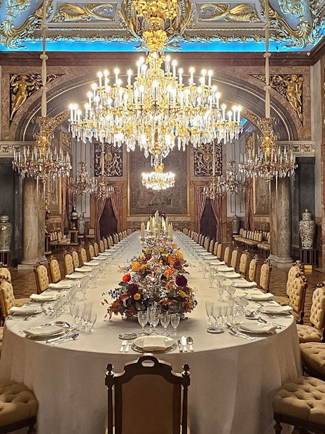 Royal Palace of Madrid dining hall with chandeliers and ornate decor.