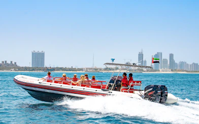 Speedboat with tourists on Dubai Marina tour, city skyline in background.