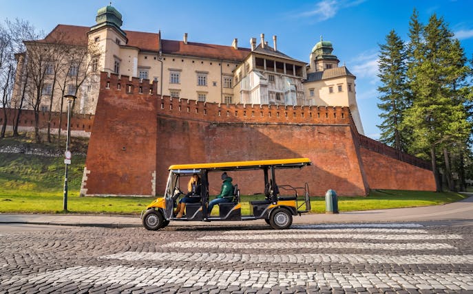Golf cart tour passing Wawel Castle in Krakow Old Town.