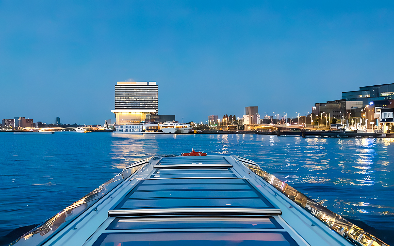 Evening cruise view of city skyline and waterfront building.