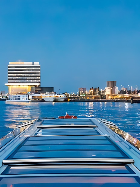 Evening cruise view of city skyline and waterfront building.