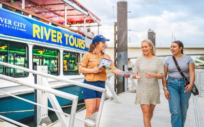 River City Cruises staff member gives tour information to guests at Brisbane dock.