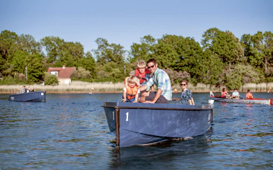 Family enjoying a boat tour in Copenhagen harbor with city views and landmarks.