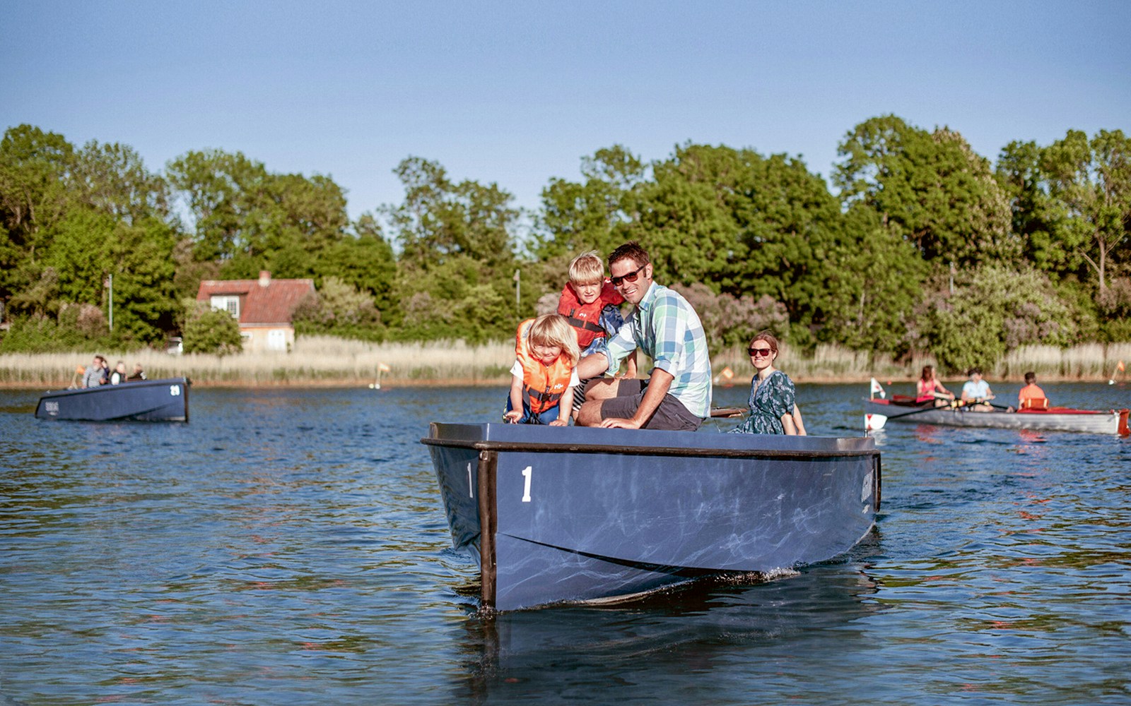 Family on a boat tour in Copenhagen harbor, viewing city landmarks and skyline.