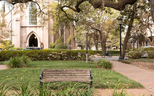 Historic church and park bench in Savannah, Georgia, part of the Ghosts of Savannah exploration game.