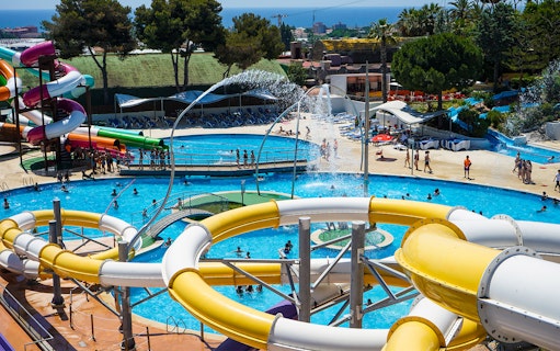 Water slides and pools at Illa Fantasia Water Park, Barcelona, with visitors enjoying the attractions.