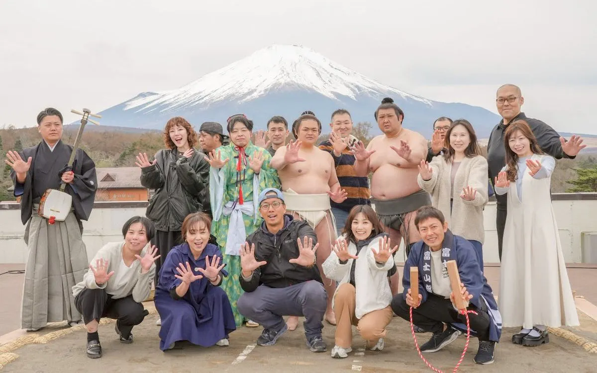 Group posing with Mount Fuji backdrop at Yamanashi Sumo Show Experience.