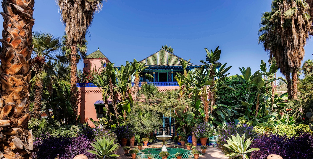 Jardin Majorelle garden with vibrant plants and a central fountain in Marrakech, Morocco.