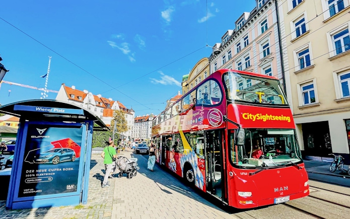 CitySightseeing bus at Wiener Platz with historic buildings in the background.