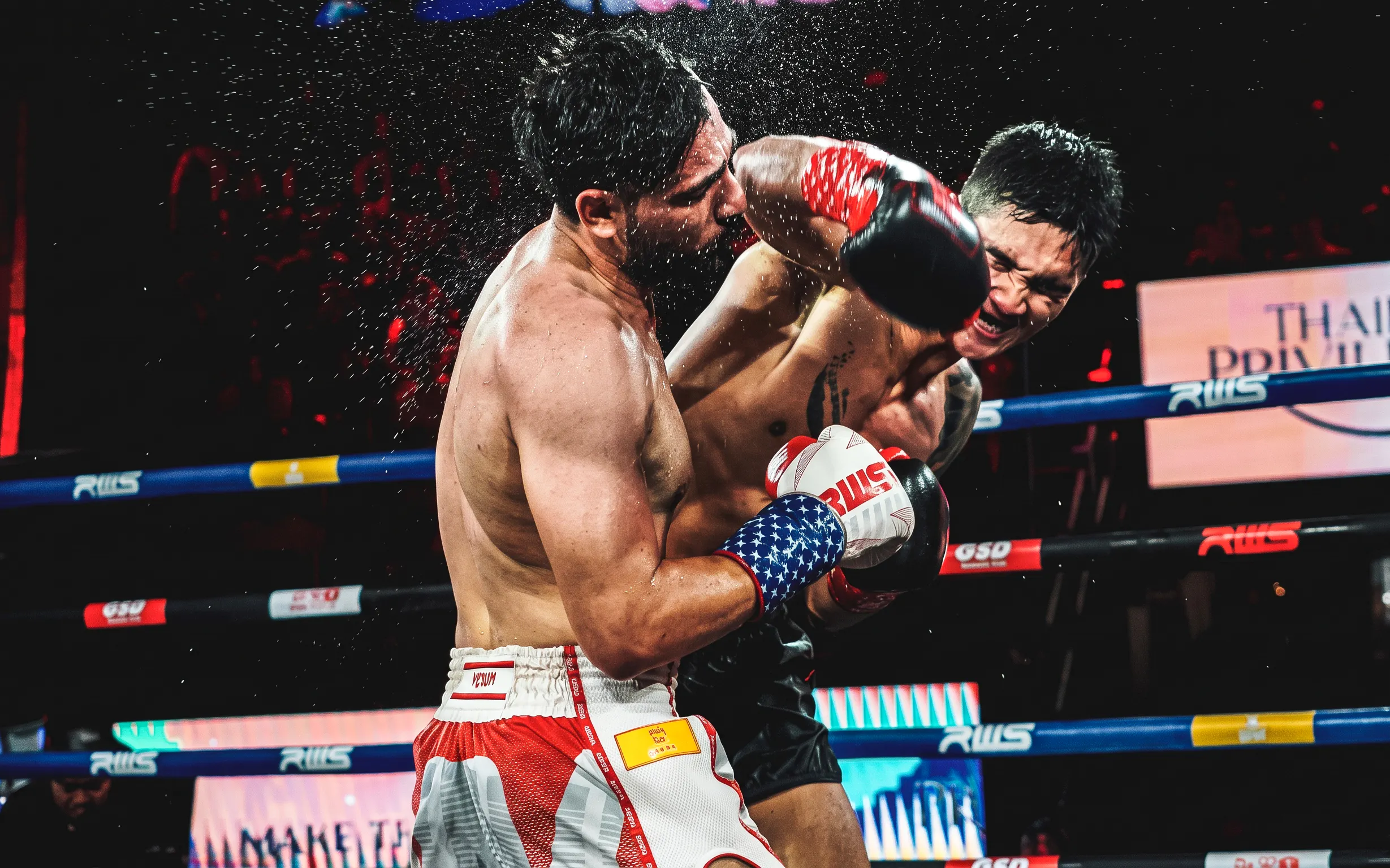Muay Thai fighters exchanging punches at Rajadamnern Stadium, Bangkok.