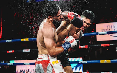 Muay Thai fighters exchanging punches at Rajadamnern Stadium, Bangkok.