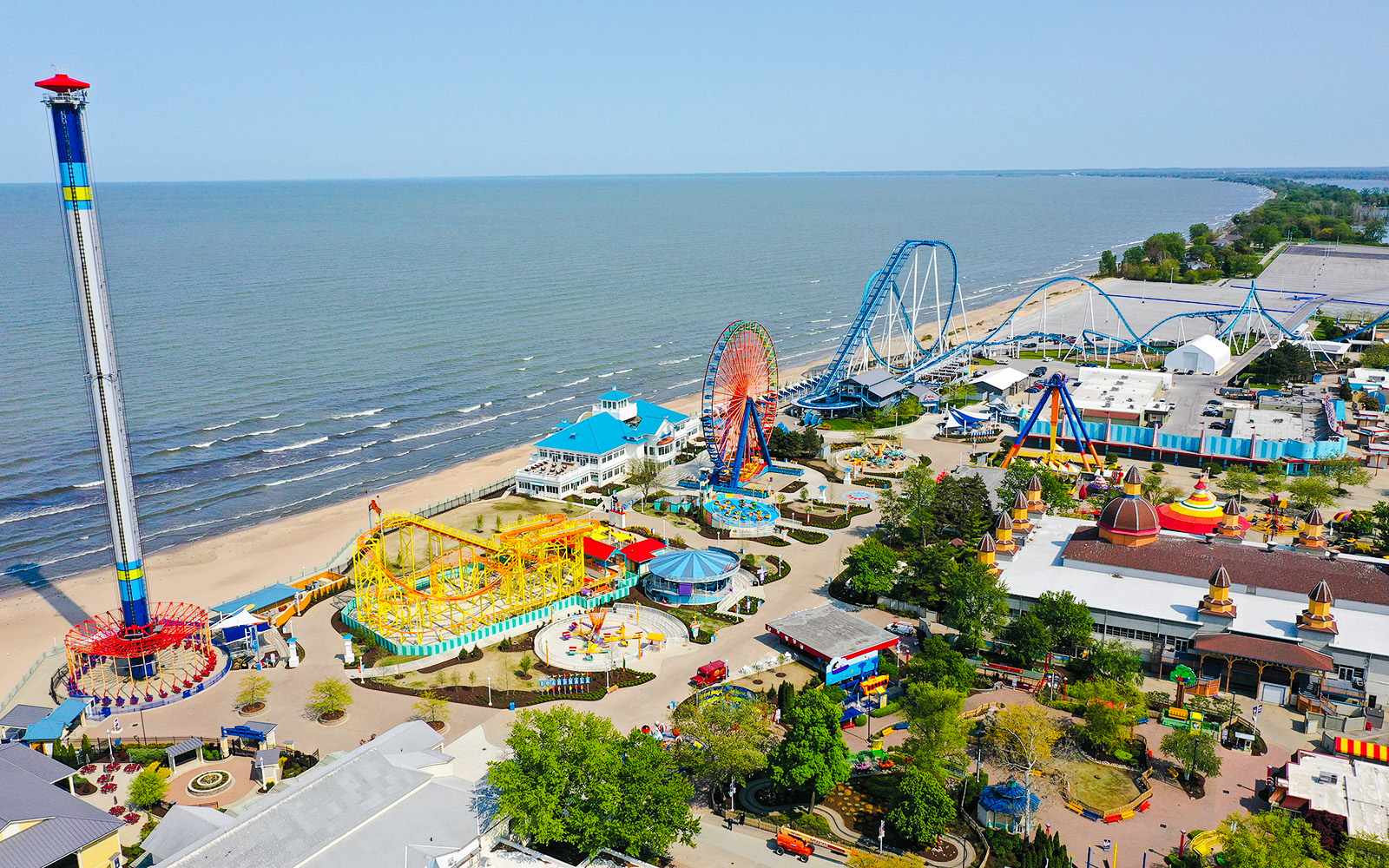 Cedar Point Boardwalk with roller coasters, Ferris wheel, and lakeside view.