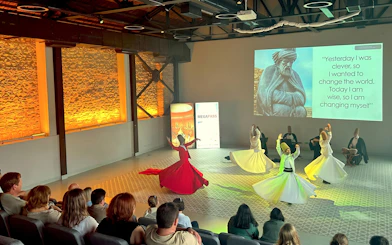 Whirling dervishes performing in Istanbul with audience watching.