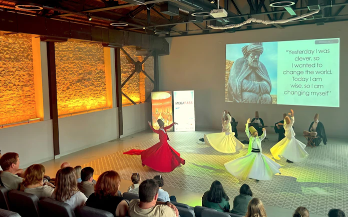 Whirling dervishes performing in Istanbul with audience watching.