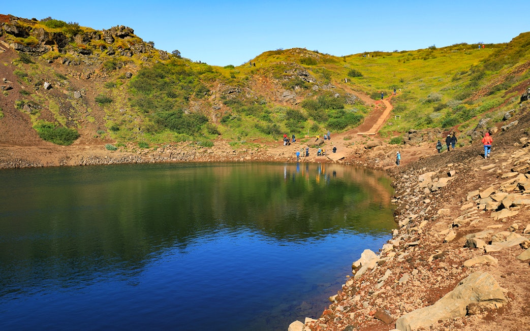 Kerid Crater with visitors walking along the path, part of the Golden Circle tour from Reykjavik.