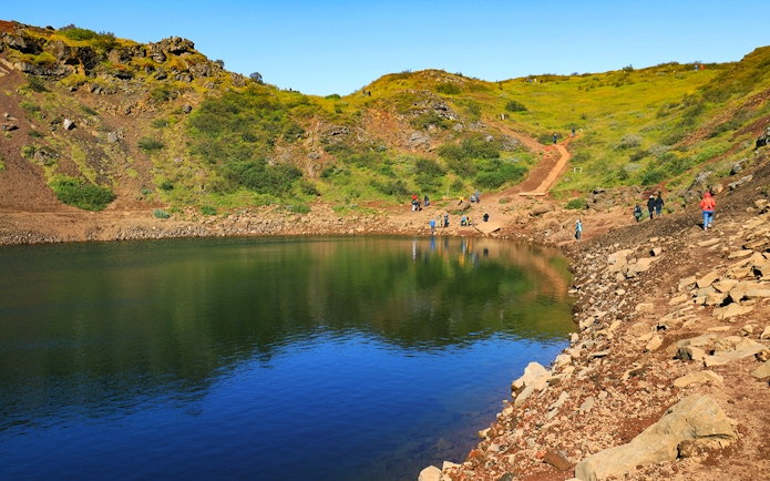 Kerid Crater with visitors walking along the path, part of the Golden Circle tour from Reykjavik.