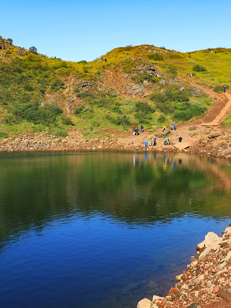 Kerid Crater with visitors walking along the path, part of the Golden Circle tour from Reykjavik.