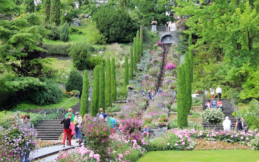 Visitors exploring the vibrant gardens and stone steps on Mainau Flower Island.