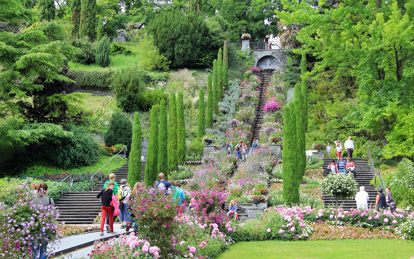 Visitors exploring the vibrant gardens and stone steps on Mainau Flower Island.