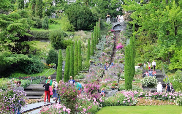 Visitors exploring the vibrant gardens and stone steps on Mainau Flower Island.