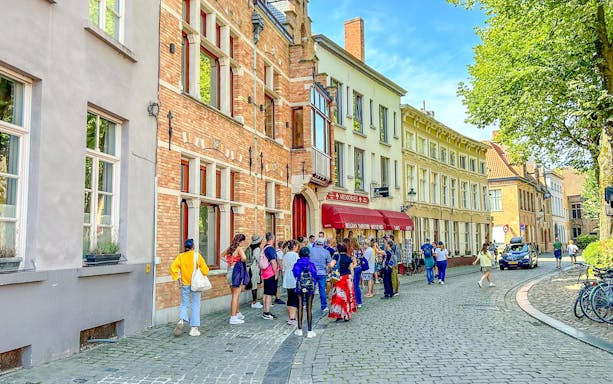 Tour group exploring historic street in Bruges, Belgium.