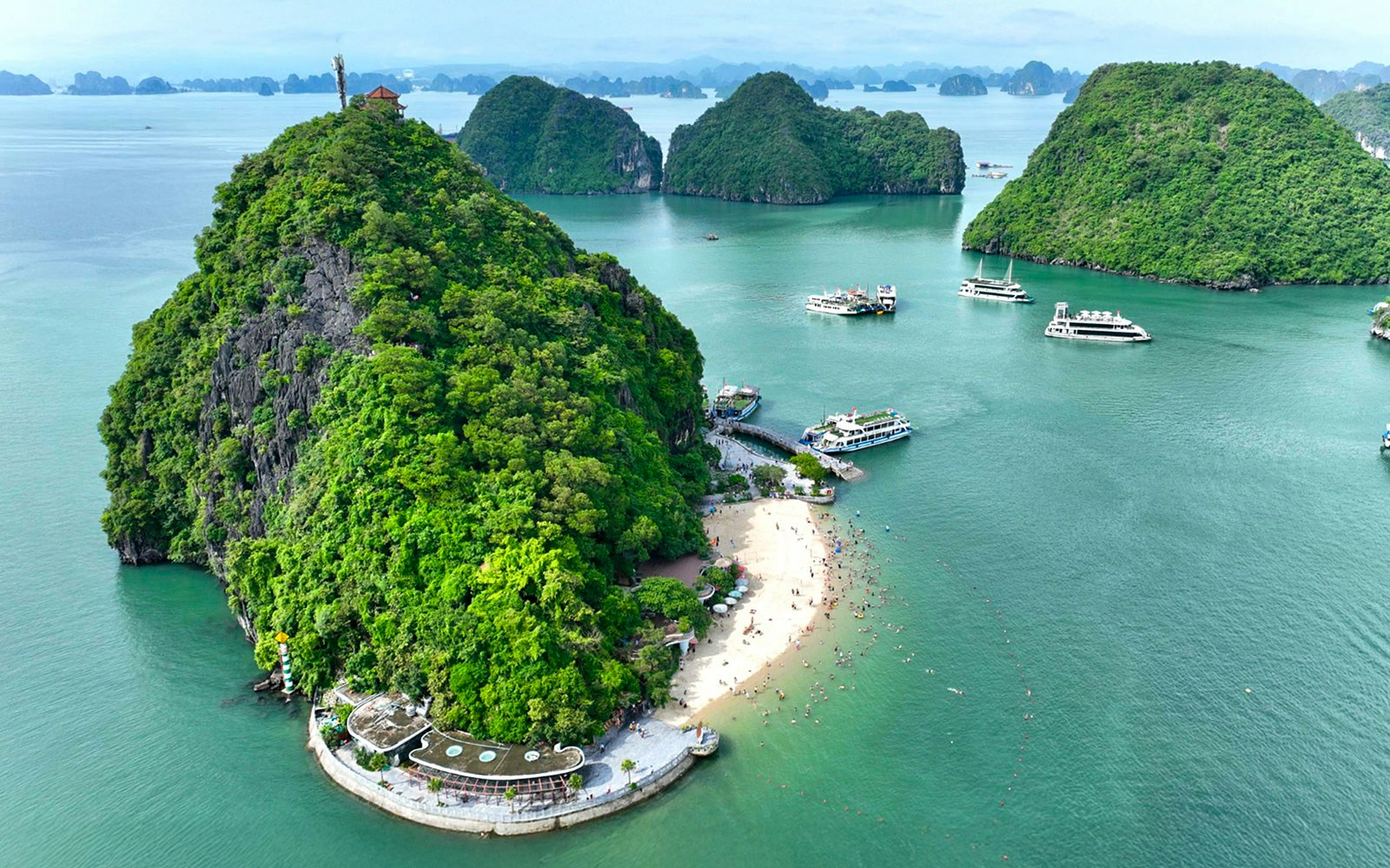 Ha Long Bay 5-Star Cruise ship sailing past limestone karsts and emerald waters in Vietnam.