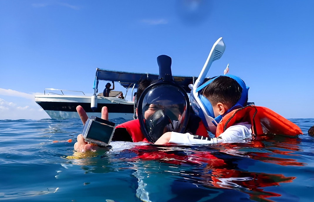 Snorkelers in life vests near a boat