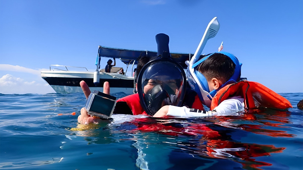 Snorkelers in life vests near a boat
