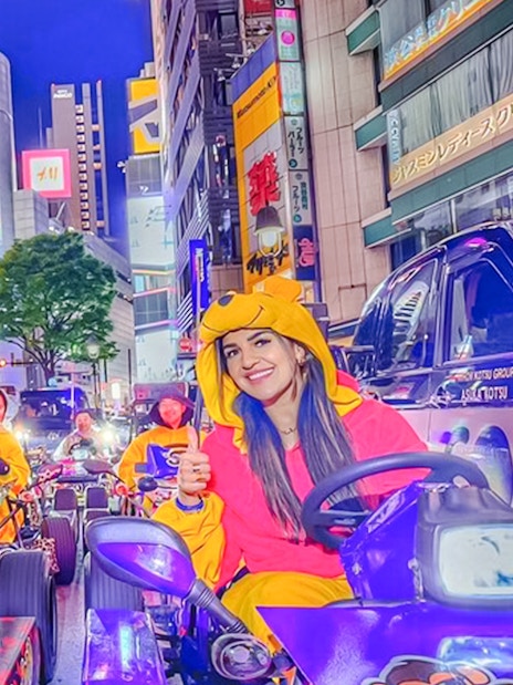 Go-kart parade in Shinjuku, Tokyo with participants in colorful costumes.