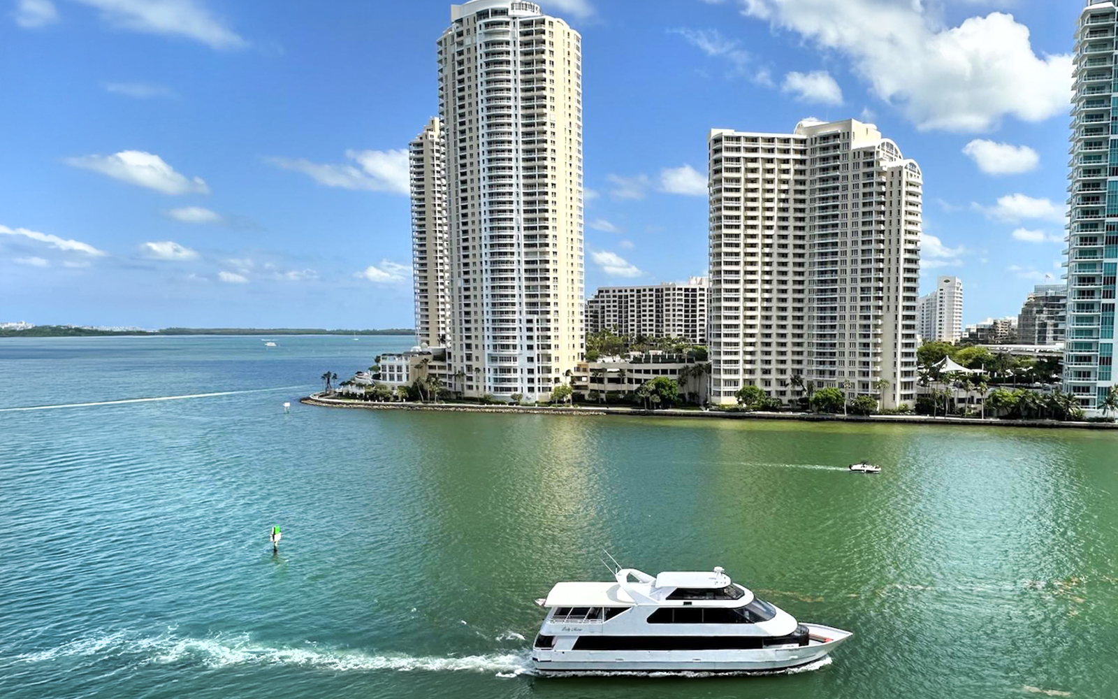 Boat cruising near high-rise buildings on Miami's waterfront.