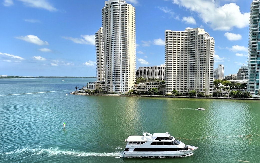Boat cruising near high-rise buildings on Miami's waterfront.