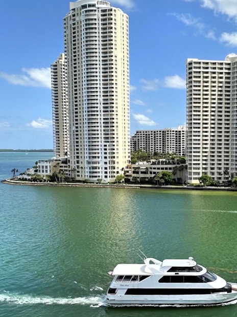 Boat cruising near high-rise buildings on Miami's waterfront.
