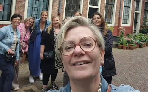 Group enjoying a self-guided city exploration game in Haarlem courtyard.