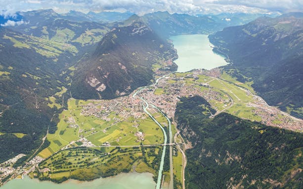 Aerial view of Swiss Alps with lakes and valleys during a private helicopter flight.