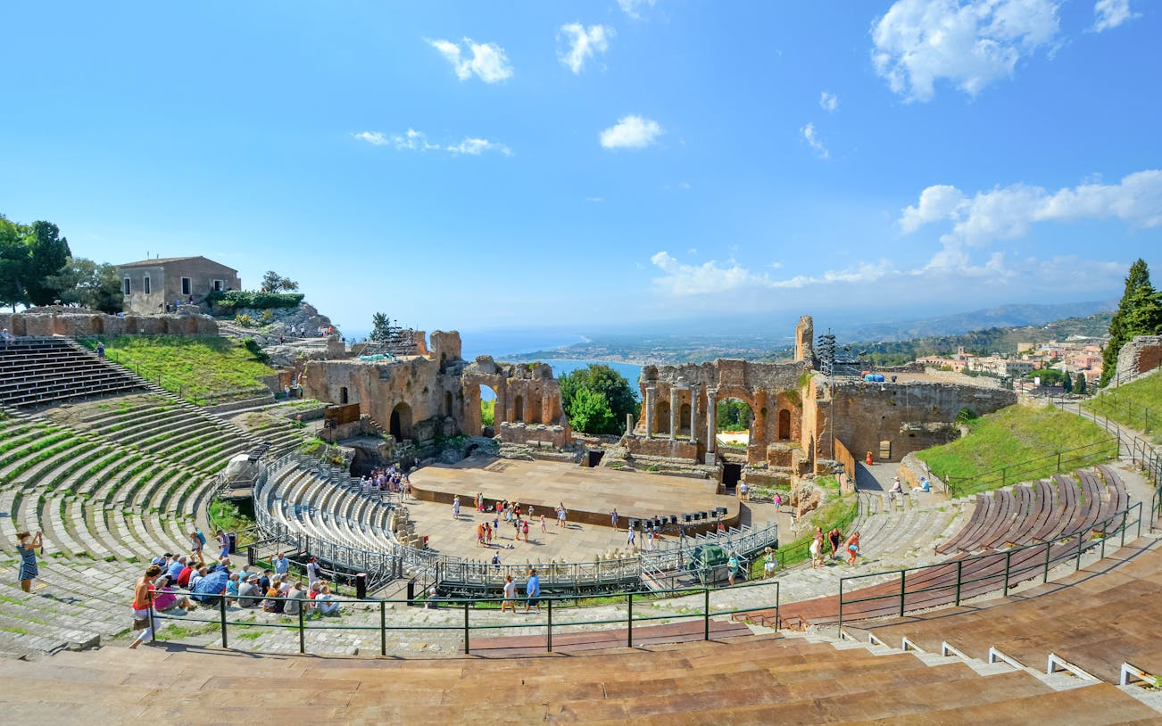 Greek Theatre in Taormina, Sicily with Mediterranean Sea view in background.