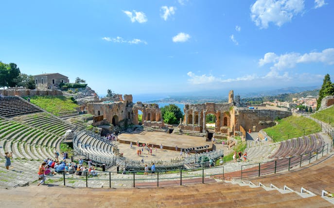Greek Theatre in Taormina, Sicily with Mediterranean Sea view in background.