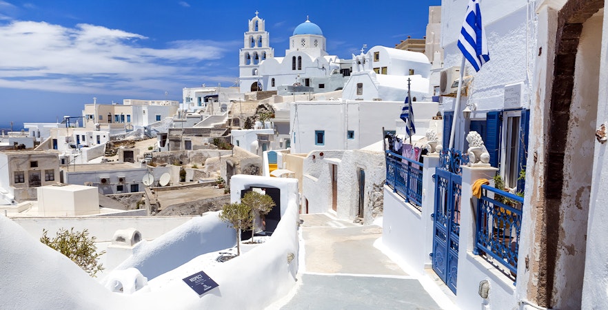 Whitewashed buildings and blue domes in Pyrgos village, Santorini, Greece.